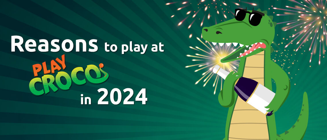 Croco with sunglasses holding a sparkler with fireworks in the background.